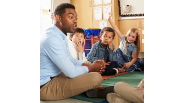 teacher with children sitting on a rug